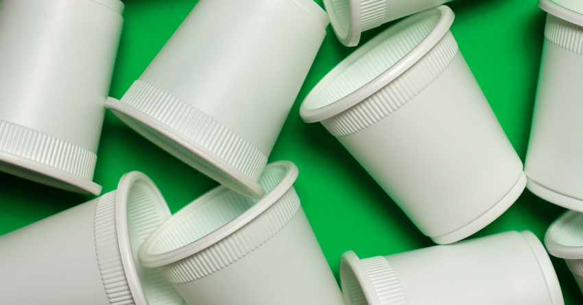 Bioplastic cups on a green background