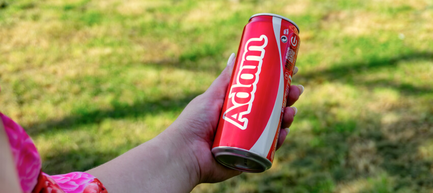 Hand holding a red Coca-Cola can with 