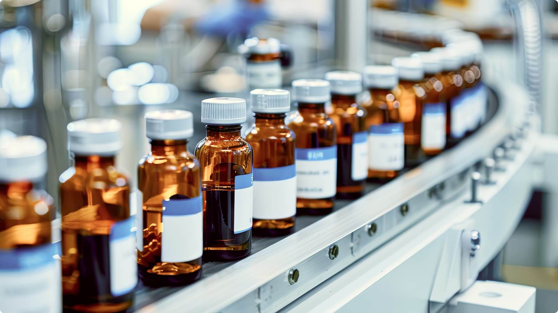 A row of amber glass laboratory bottles with white caps and blue-and-white labels arranged on a metal shelf in a pharmaceutical or research facility.